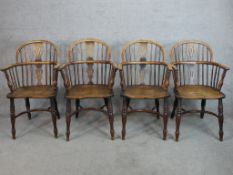 A set of four 19th century elm Windsor chairs with pierced splat and spindle backs raised on