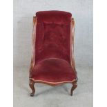 A 19th century carved mahogany show framed upholstered button back nursing chair raised on carved