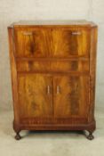 An Art Deco style fitted walnut drinks cabinet, with accessories above two cupboard doors standing