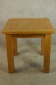 A contemporary oak square topped occasional table raised on square supports. H.79 W.80 D.80cm.