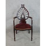 A 20th century carved 'tulip' mahogany framed open arm chair with red upholsetered seat raised on