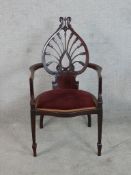 A 20th century carved 'tulip' mahogany framed open arm chair with red upholsetered seat raised on