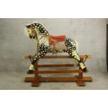 An early 20th century Collinson rocking horse, painted in dapple grey with red leather seat and