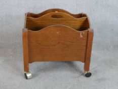 A 20th century oak floor standing magazine/newspaper rack with central carrying handle and twin