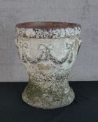 A 20th century painted terracotta garden planter with swag and bow decoration raised on circular