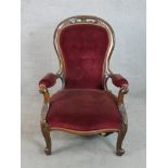 A 19th century mahogany show framed button back spoonback armchair raised on carved cabriole