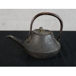 A 19th/early 20th century Japanese cast iron teapot with swing handle. H.15 W.21 D.15cm