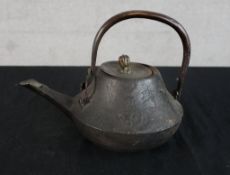 A 19th/early 20th century Japanese cast iron teapot with swing handle. H.15 W.21 D.15cm
