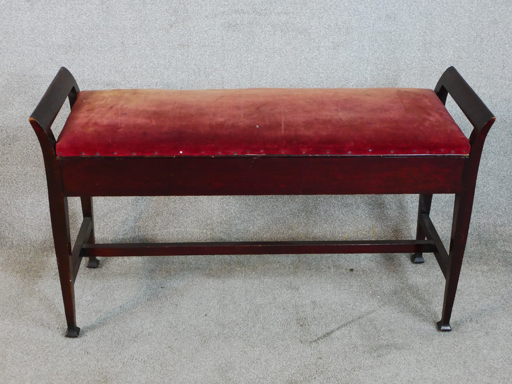 An early 20th century mahogany framed duet piano stool raised on tapering supports terminating in