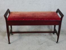 An early 20th century mahogany framed duet piano stool raised on tapering supports terminating in