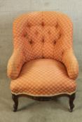 A 19th century carved mahogany framed button back low nursing chair raised on carved cabriole