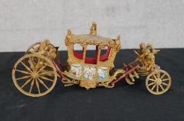 A 20th century scale model of the Coronation carriage, with hand painted decoration. H.9 W.22 D.10cm