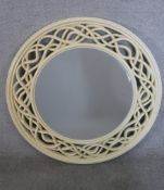 A contemporary white 'Celtic' design circular wall mirror. D.108cm