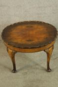 A 20th century carved walnut circular topped coffee table raised on tapering supports terminating in
