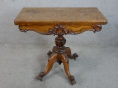 A 19th century walnut foldover card table, the faceted central column raised on four carved cabriole
