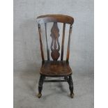 An 18th century style beech nursing chair with pierced splat back raised on splayed turned