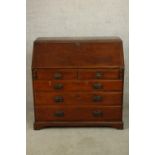A George III oak fall front bureau with fitted interior, raised on two short over three long drawers