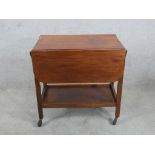A mid 20th century mahogany drop flap two tier trolley raised on square supports terminating in