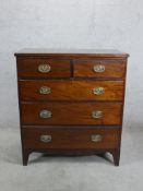 A George III mahogany chest of two short over three long drawers with brass swing handles raised