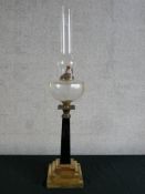 A late 19th century oil lamp with tapering grey marble/hardstone column raised on stepped brass