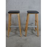 A pair of contemporary pine and leather stools raised on square splayed supports with metal foot