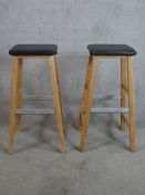 A pair of contemporary pine and leather stools raised on square splayed supports with metal foot