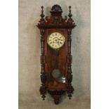 A late 19th/early 20th century mahogany Vienna style regulator with carved cornice and turned