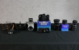 A collection of cameras to include a Praktisix and Prakica BMS. Also, three lenses. The largest