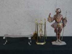 A vintage cast iron fireside companion set in the form of a court figure together with a 20th