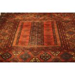 Large Persian rug. Geometric design on a burgundy field within multiple floral borders. L.350 x W.