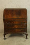 An early 20th century mahogany fall front bureau, the flap opening to reveal fitted interior with