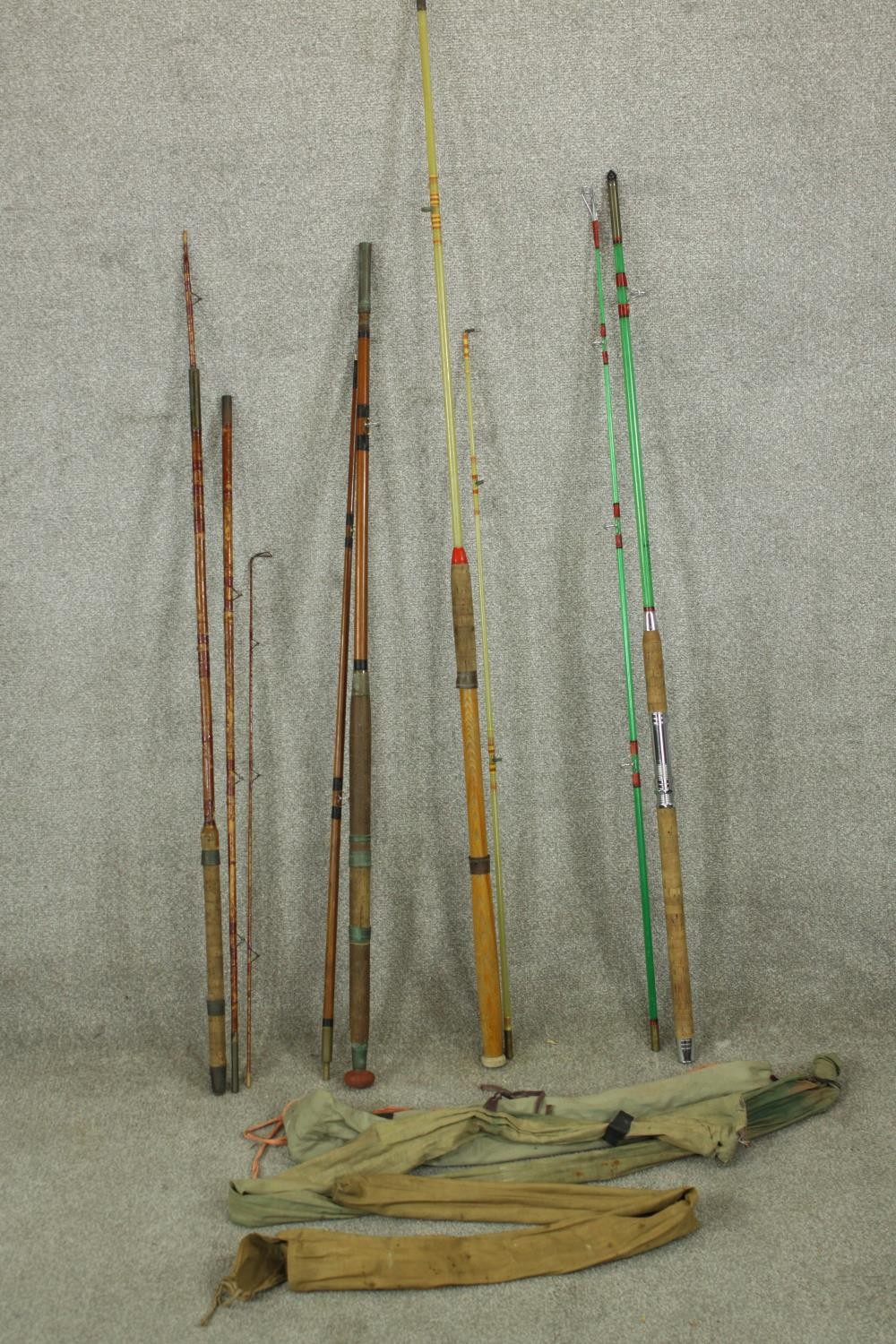 Two 20th century fibre glass fishing rods together with two early 20th century split cane fishing