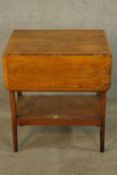 A late 19th/early 20th century mahogany drop leaf table with undertier raised on turned tapering