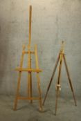 Two beech floor standing artists easels each raised on three splayed adjustable supports.