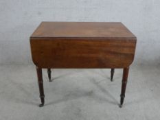 A George III mahogany Pembroke table raised on turned supports terminating in brass casters. H.71