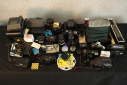 A collection of camera gear. Including Nikon SLR and Polaroid cameras. H.24 x W.23 cm. (largest).