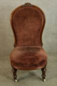 A 19th century mahogany framed spoon back ladies nursing chair upholstered in red fabric, raised