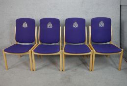 A set of four contemporary beech framed stacking chairs raised on tapering supports, each with