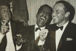 A framed black and white photograph of Frank Sinatra, Sammy Davis and Dean Martin. H.65 W.85cm.