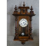 A 19th century mahogany cased Vienna type wall clock. the white dial with black Roman numerals. H.76