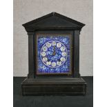 A late 19th century ebonised Architectural mantle clock, the blue and white enamel dial with black
