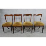 A set of four Victorian mahogany framed bar back dining chairs with stuffover seats raised on turned