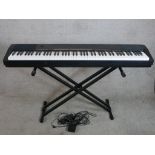 An electric Casio keyboard and stand. H.80 W.135cm
