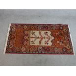 A modern red ground woollen rug, the central ivory field with tree of life design with geometric