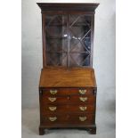 A George III mahogany bureau bookcase, the twin glazed doors opening to reveal adjustable shelves