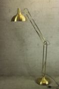 A brass floor standing anglepoise adjustable lamp.