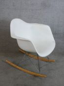 A vintage Vitra Eames RAR rocking chair with white polypropylene seats raised on wirework struts and