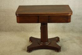 A William IV mahogany fold over table, the central hexagonal column raised from shaped platform base