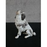 A late 19th/early 20th century Meissen porcelain model of a seated dog, impressed and painted