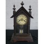 An early 20th century Junghans carved beech mantle clock, the white dial with black Roman numerals